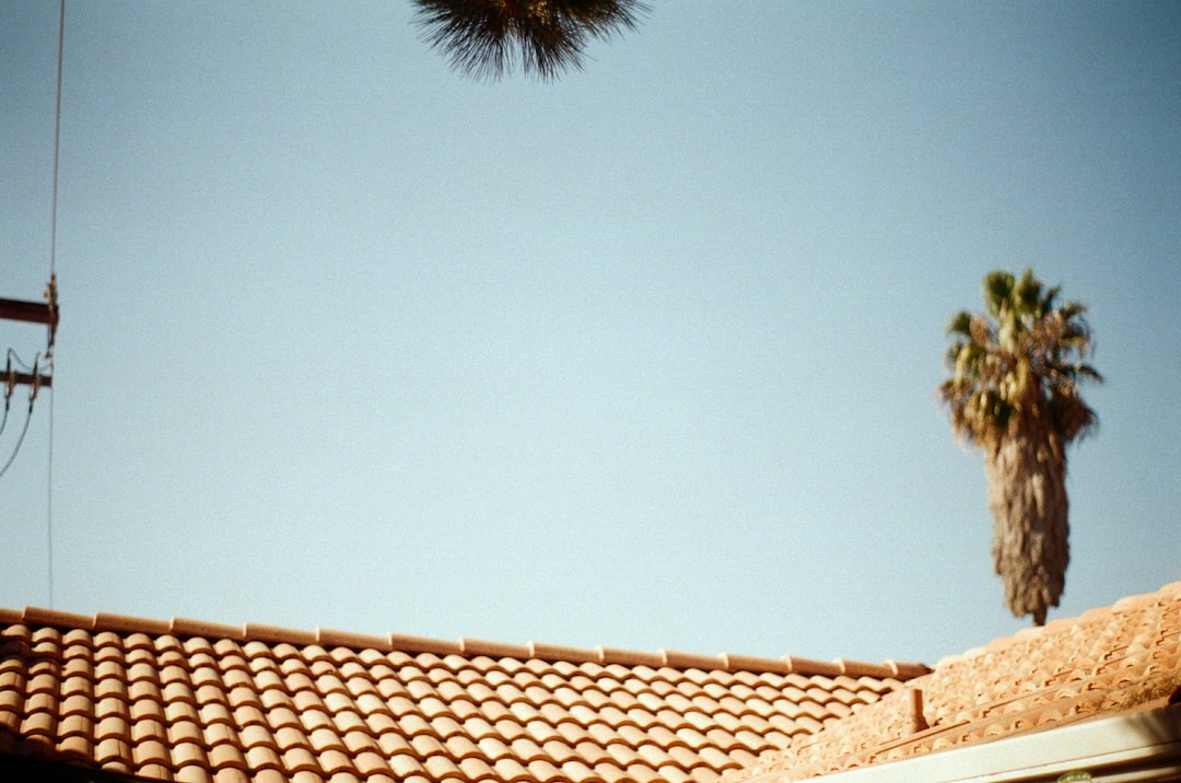 Roofing contractor working on a steep California roof without visible fall protection