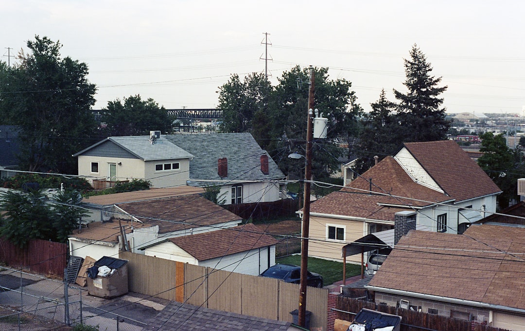 Roofing crew working on a steep residential roof in Colorado without visible fall protection