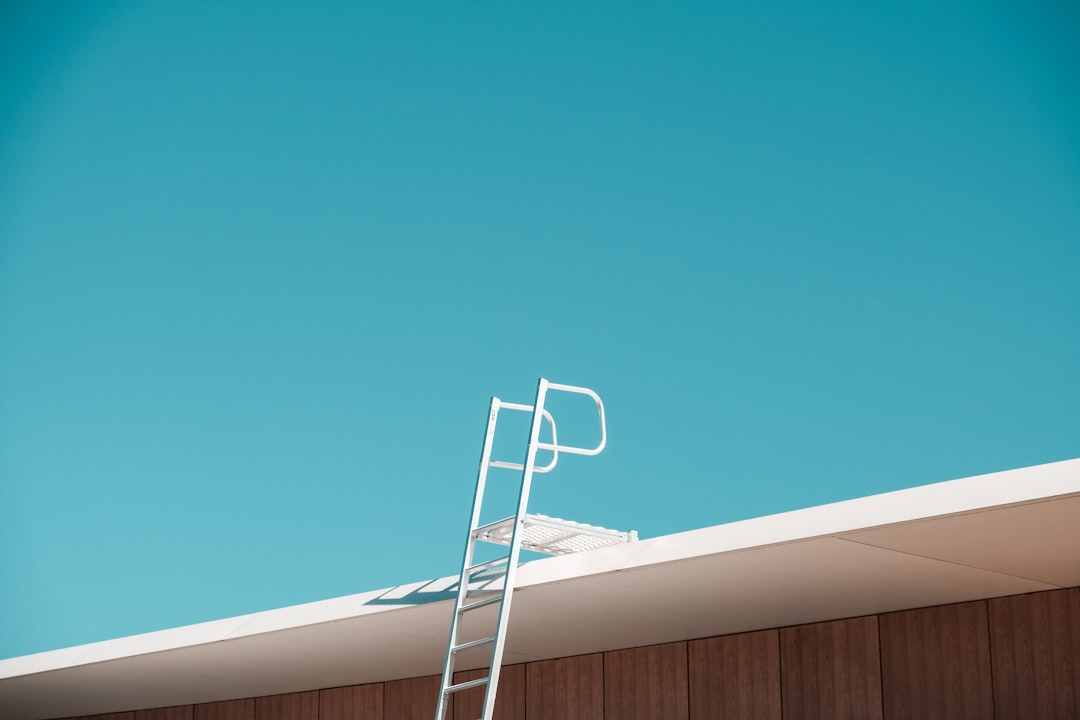 Roofing contractor on ladder illustrating North Dakota OSHA ladder violation citation