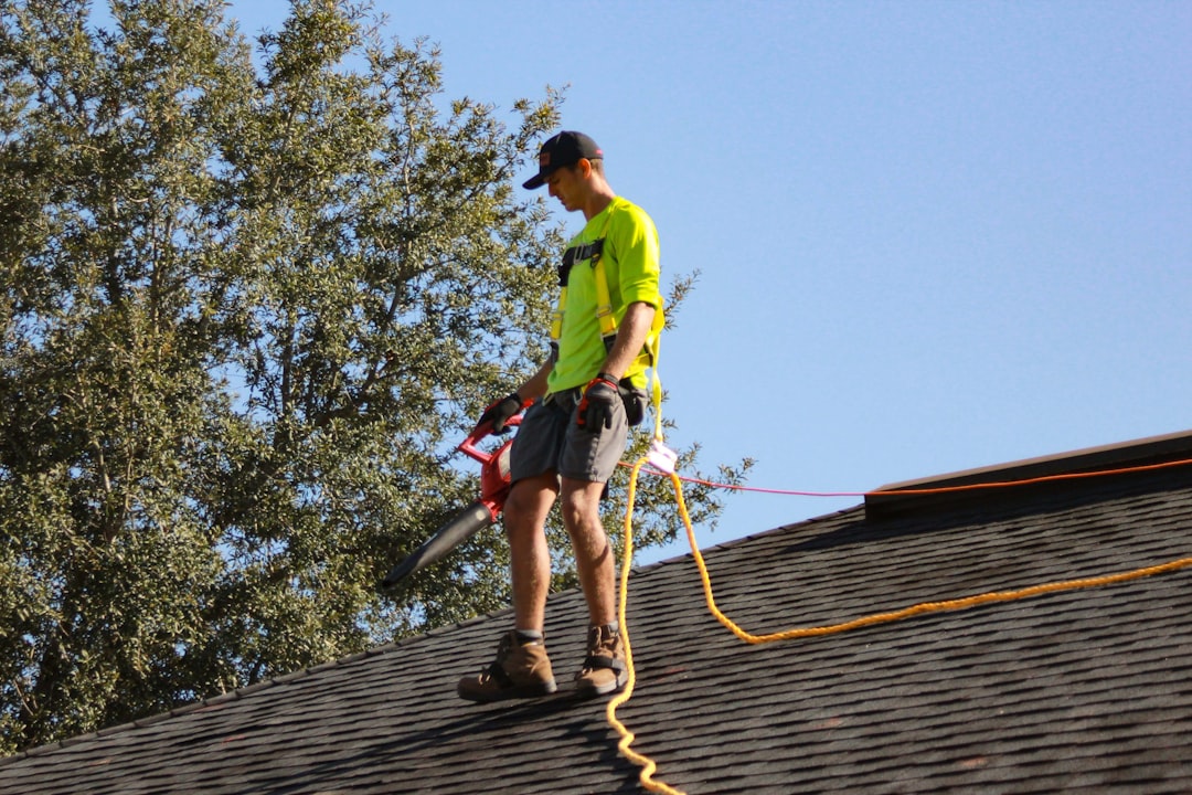 Roofing contractor on an extension ladder at a Nebraska construction site during an OSHA ladder safety inspection