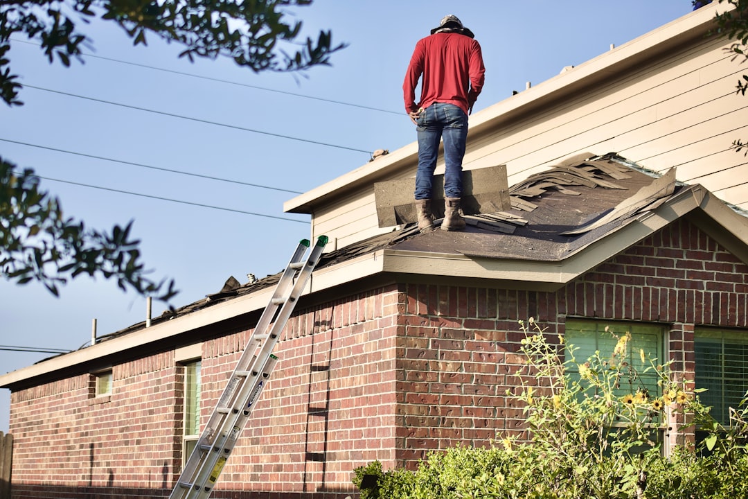 Roofing contractor on an extension ladder at a job site in Indiana following OSHA 1926.1053 ladder safety rules