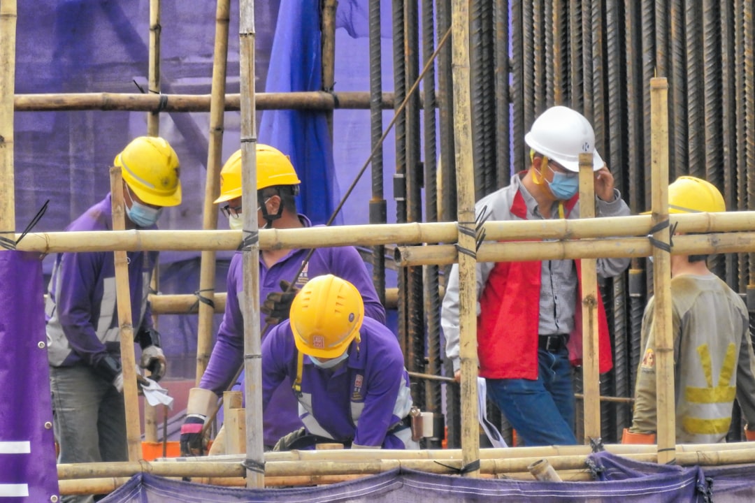 Worker inspecting scaffold guardrails on an Iowa construction site after an OSHA citation