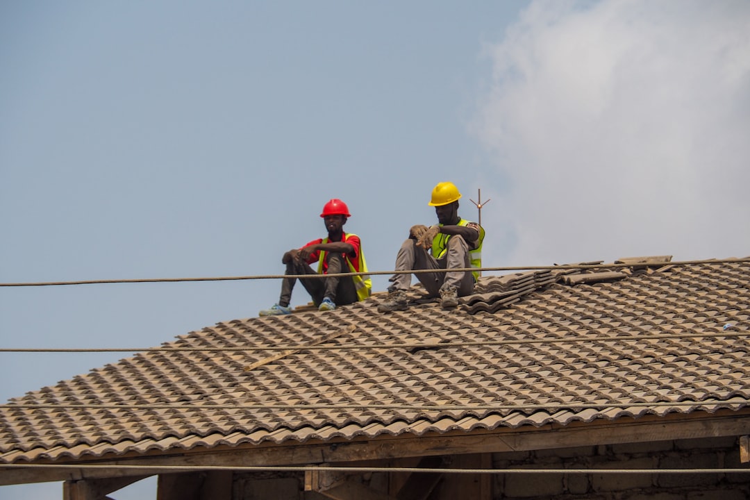 Roofing contractor climbing a ladder on a job site in Ohio, the state's most cited industry for ladder violations