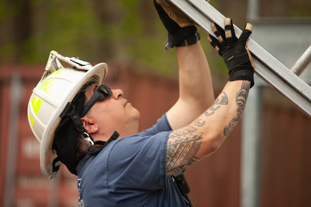 Roofing contractor climbing an extension ladder on a residential job site in Pennsylvania