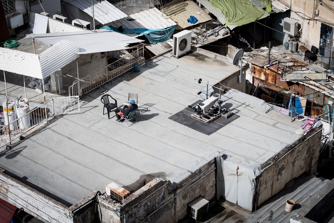 Roofing contractor working at height on a North Dakota job site without fall protection equipment