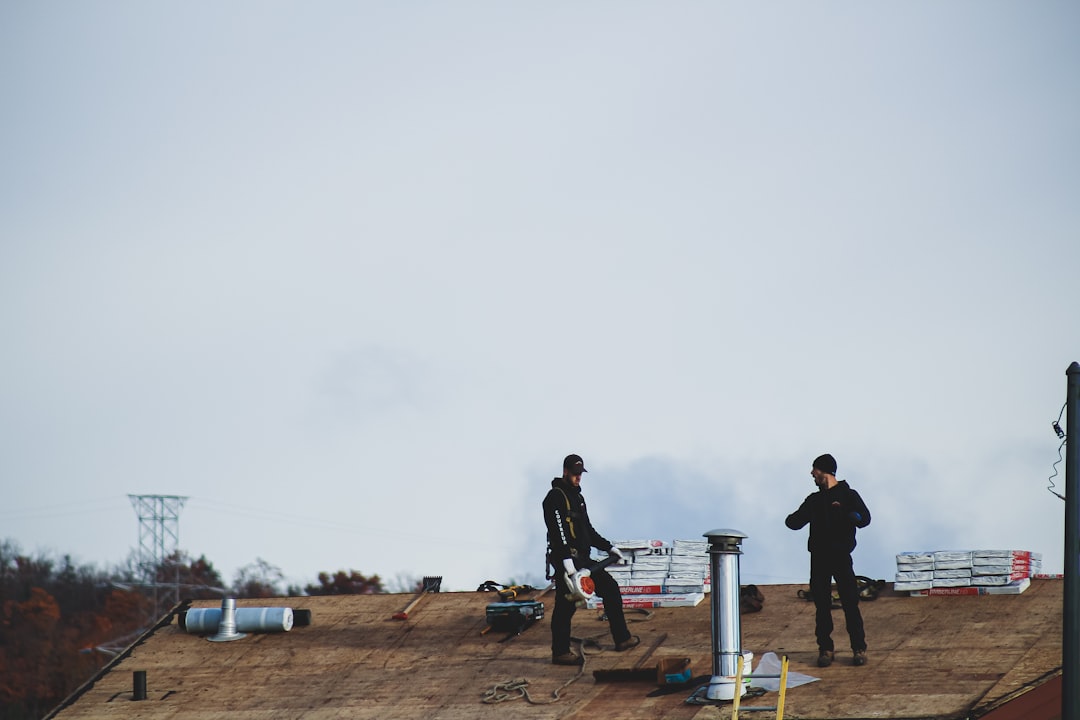 Roofing contractor working near an unprotected edge on a New Hampshire job site, illustrating a fall protection violation
