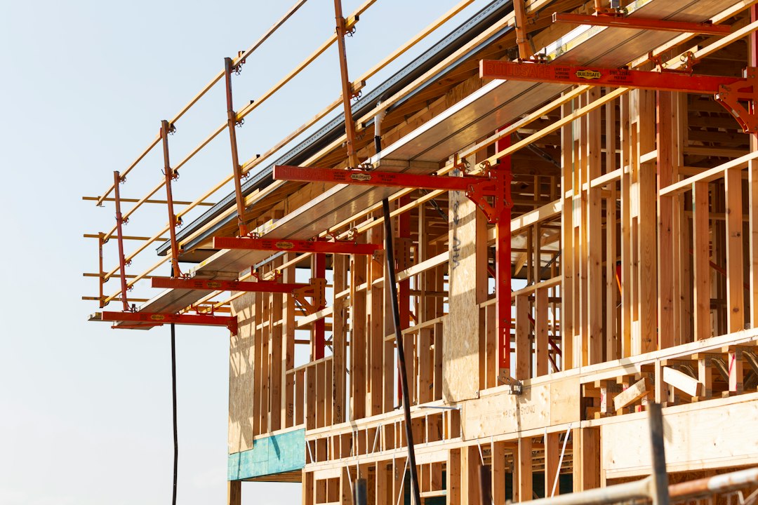 Framing contractor working on a ladder at a construction site in Alabama, illustrating OSHA ladder violation risks