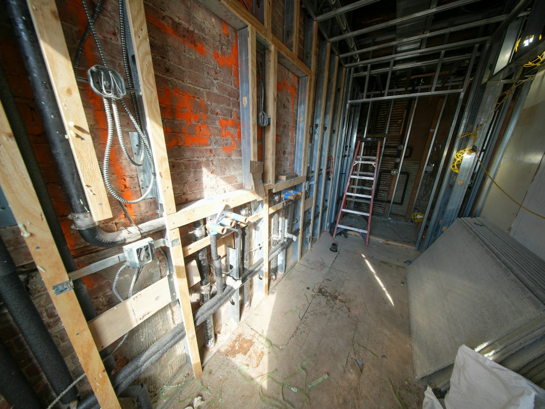 Glass and glazing contractor climbing an extension ladder on a Nebraska construction site