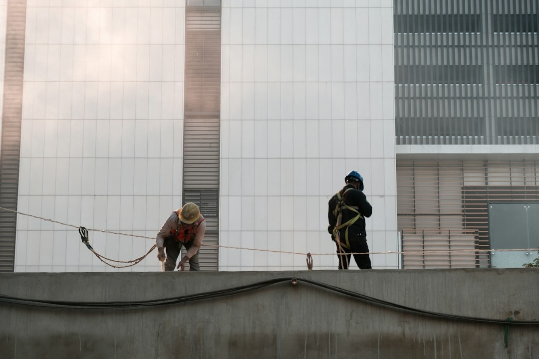 Roofing contractor working at height on an Illinois construction site without fall protection equipment