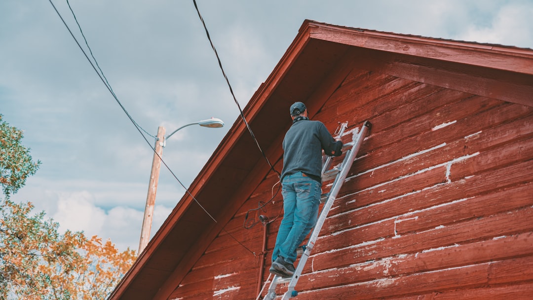 Roofing contractor on an extension ladder at a construction site in New York, illustrating an OSHA ladder violation citation