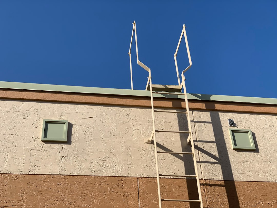 Roofing contractor climbing a ladder on a job site in Arizona, related to OSHA ladder violation citations