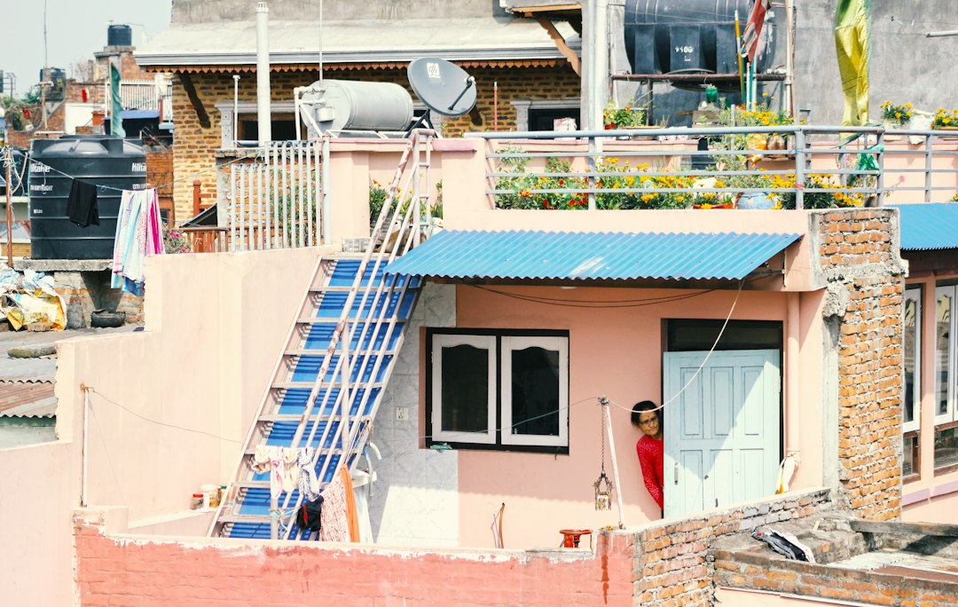 Roofing contractor climbing an extension ladder on a job site in Kansas
