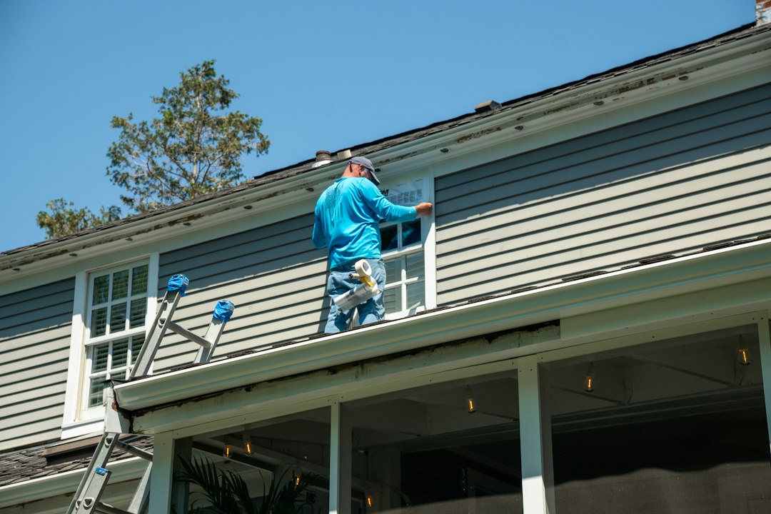 Roofing contractor climbing an extension ladder on a residential job site in Connecticut