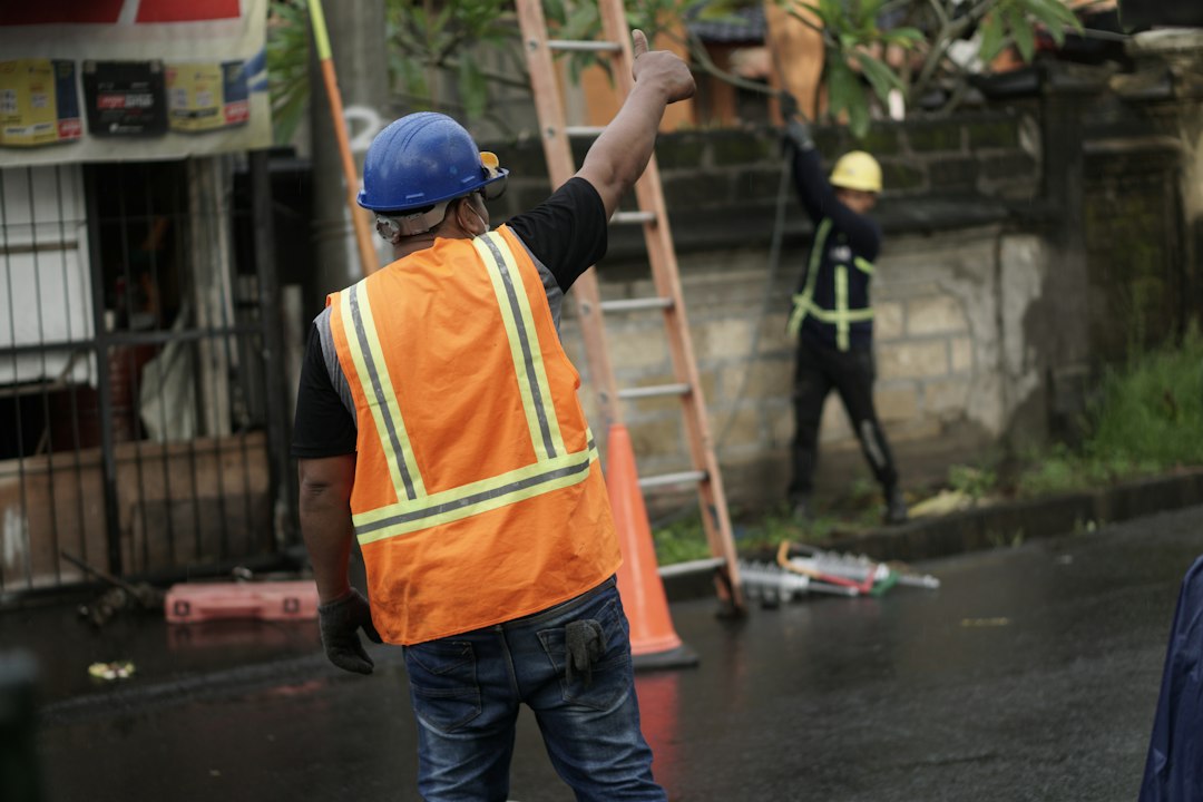 Roofing contractor climbing an extension ladder on a job site in New Hampshire, illustrating an OSHA ladder violation citation