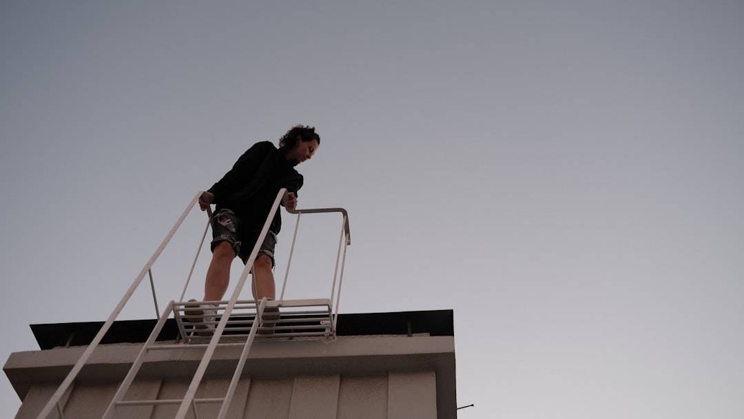 Roofing contractor working at height without fall protection equipment on an Indiana construction site