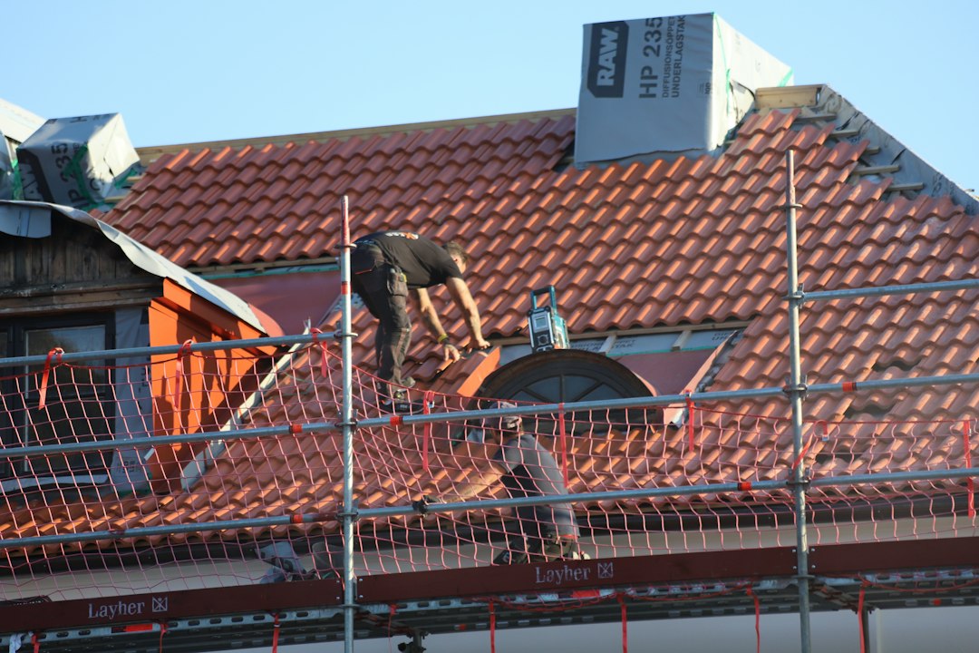 Roofing contractor working at height without fall protection on a New Mexico construction site