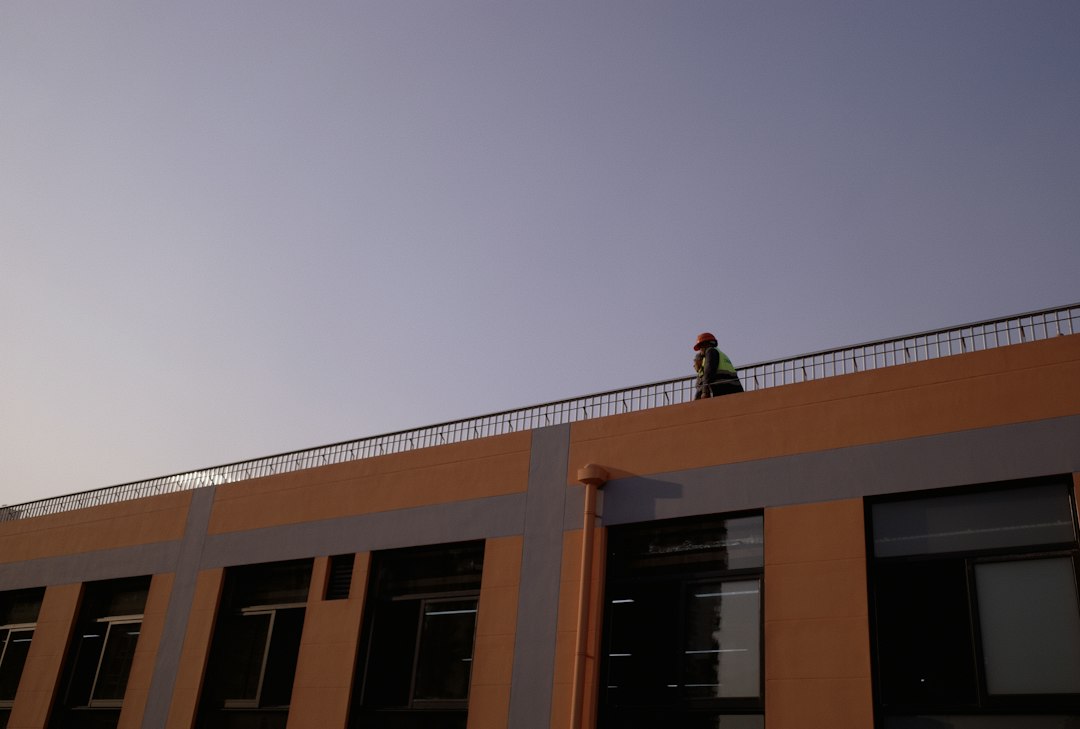 Roofing contractor working at height without fall protection equipment on a North Dakota job site