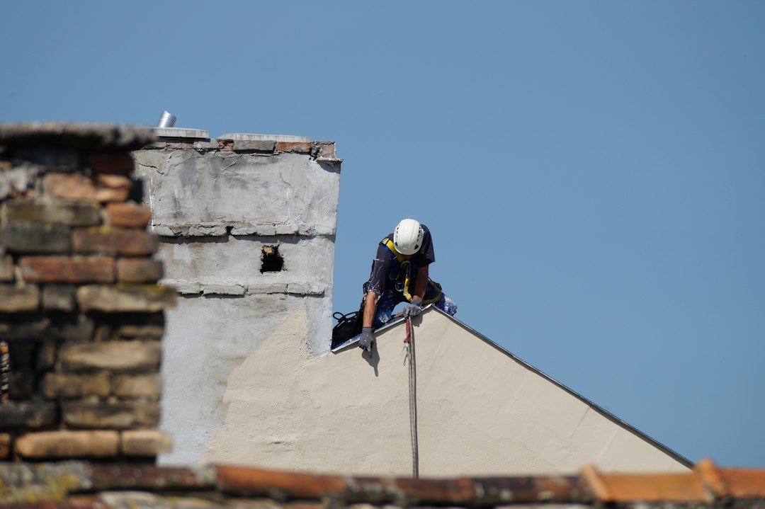 Roofing contractor working at height on a job site in West Virginia without visible fall protection equipment