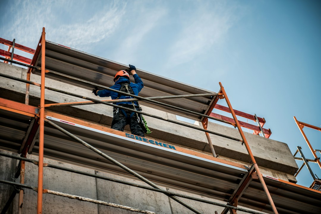 Roofing contractor working at height on a job site in Iowa without visible fall protection equipment